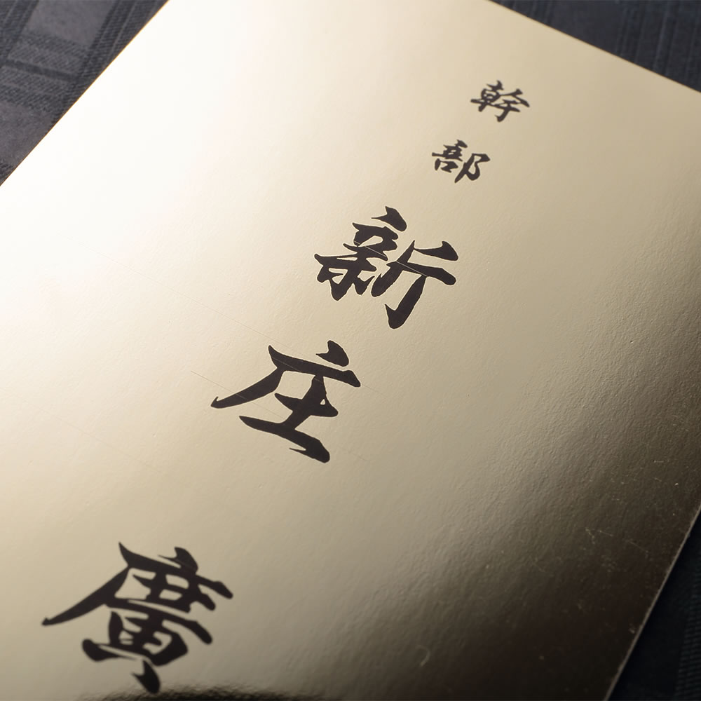 鏡面のゴールドの質感が美しい台紙に黒文字をシンプルにレイアウトした